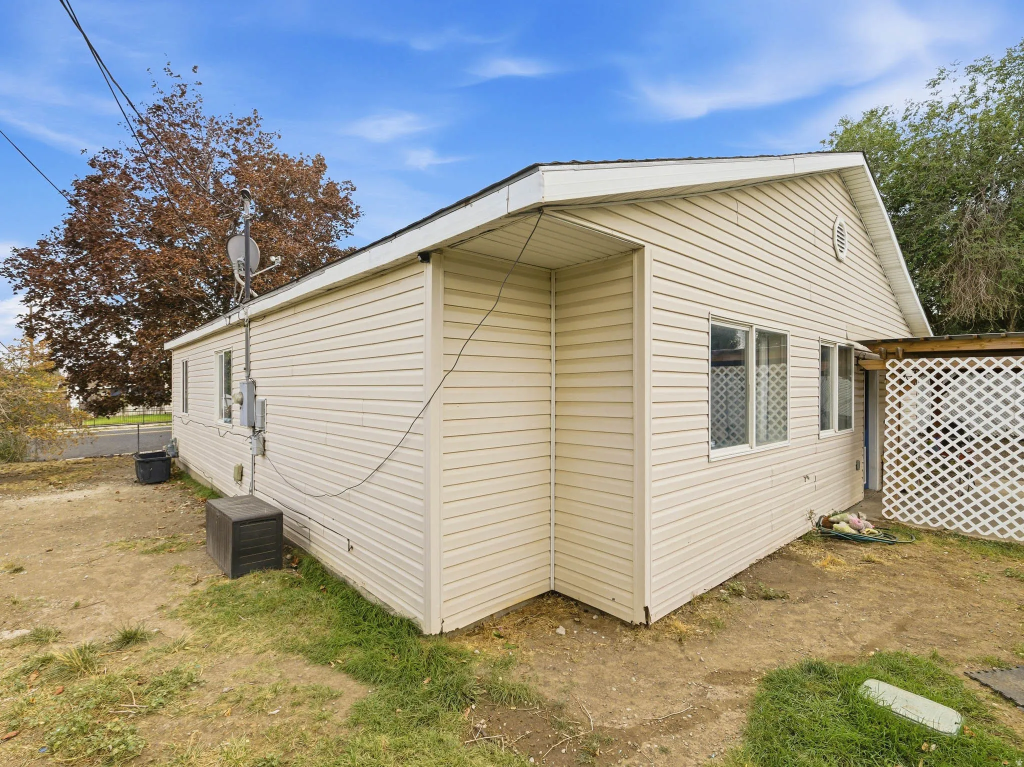 Exterior featuring horizontal siding, multiple windows, and a lattice privacy screen