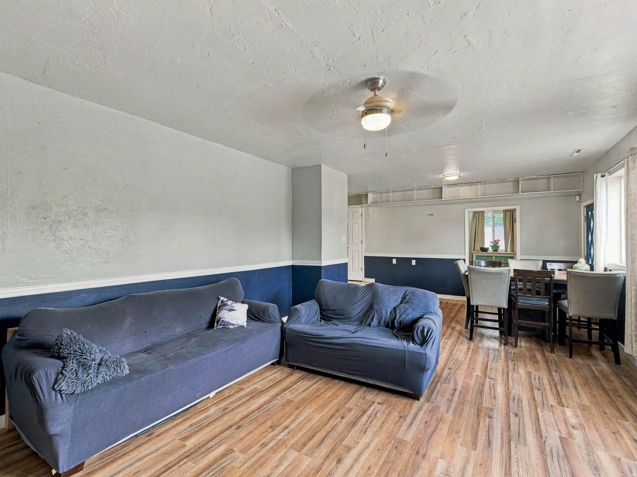 Wood-finish flooring throughout, with a ceiling fan overhead