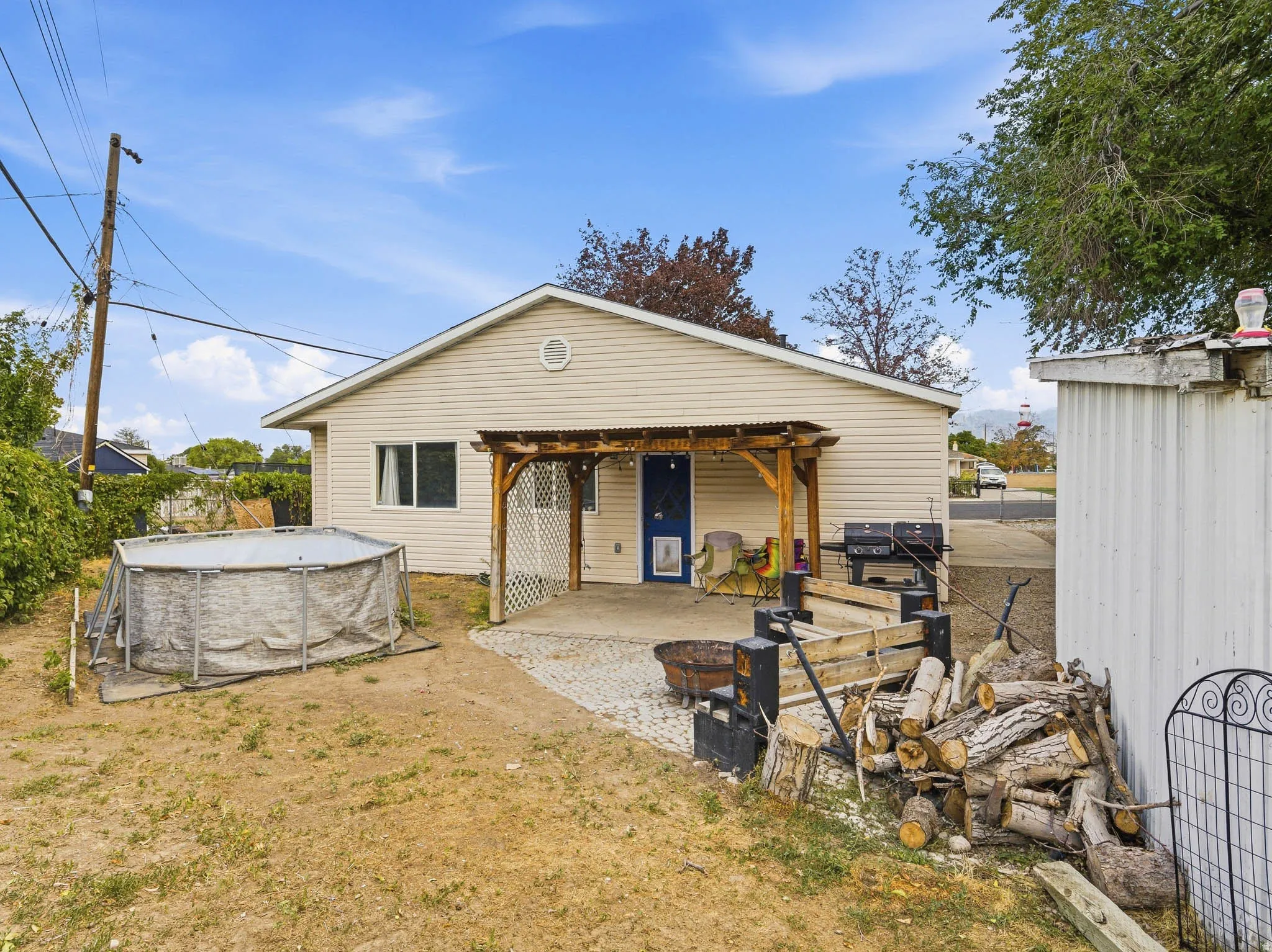 Rear exterior featuring horizontal siding, a covered patio with a wood pergola, and a concrete patio surface