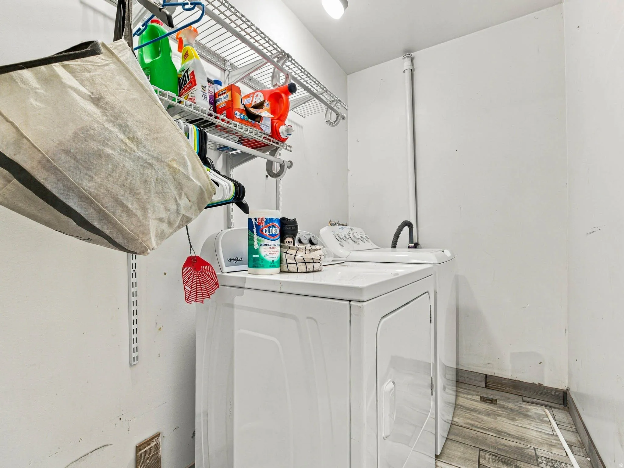 Dedicated laundry area with durable flooring and overhead wire shelving