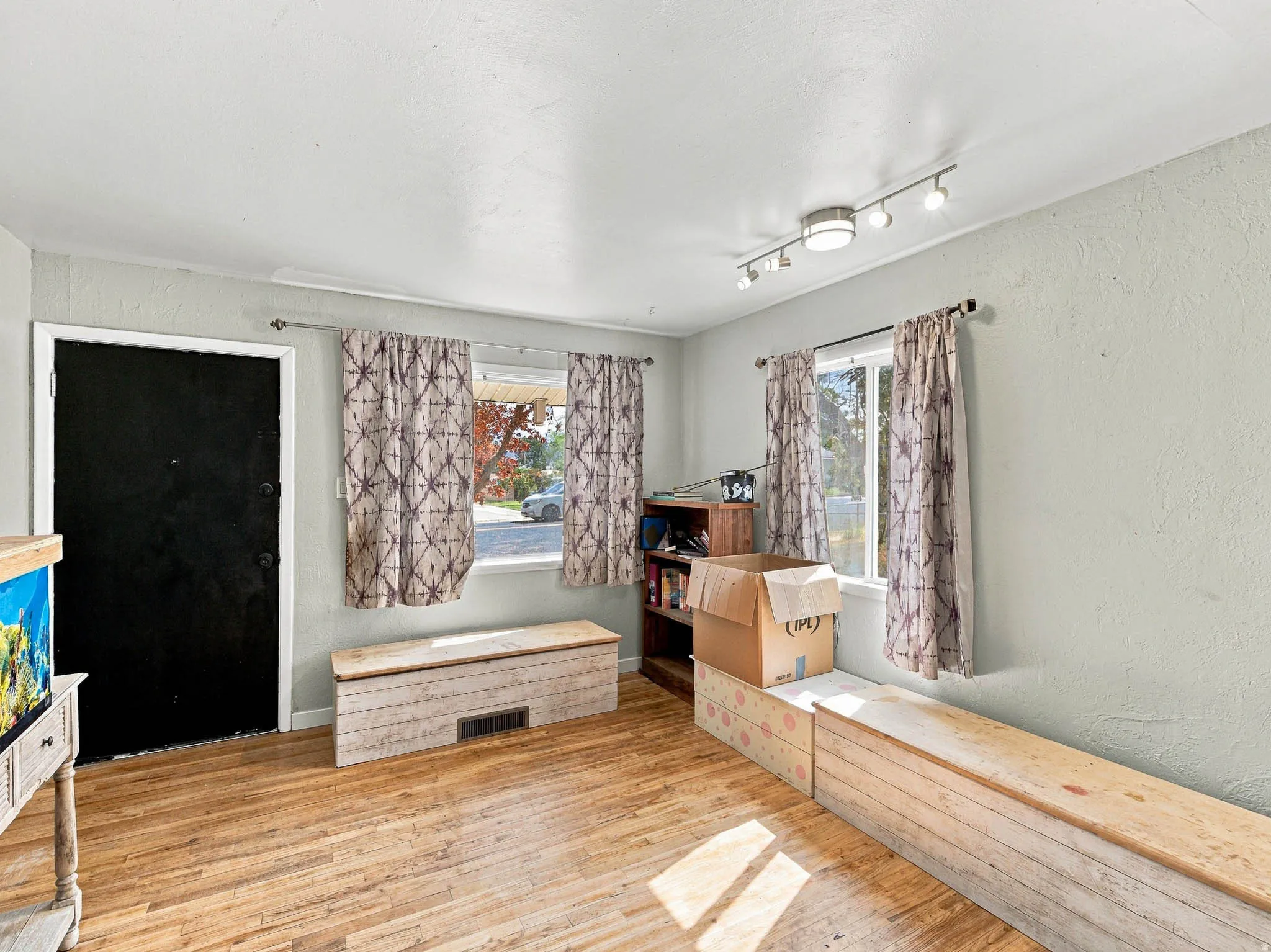 Wood-finish flooring with track lighting and multiple windows