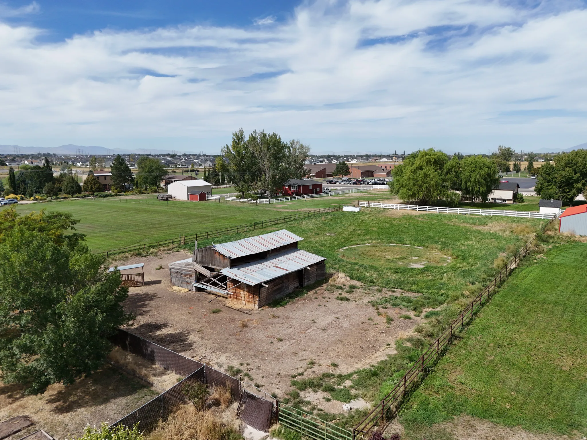 Expansive acreage featuring a rustic barn structure, split-rail fencing, and mature trees