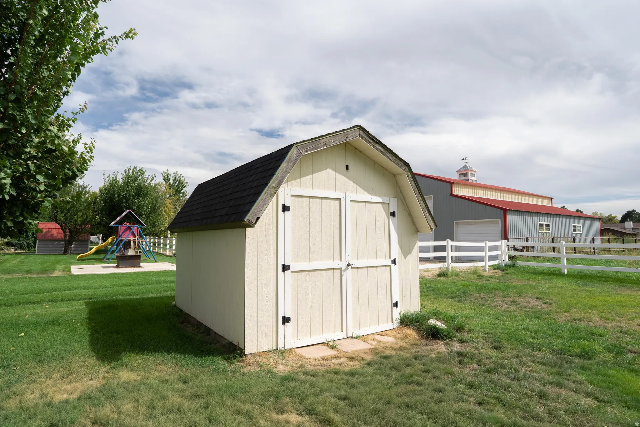 Exterior shed with double doors and black shingle roof
