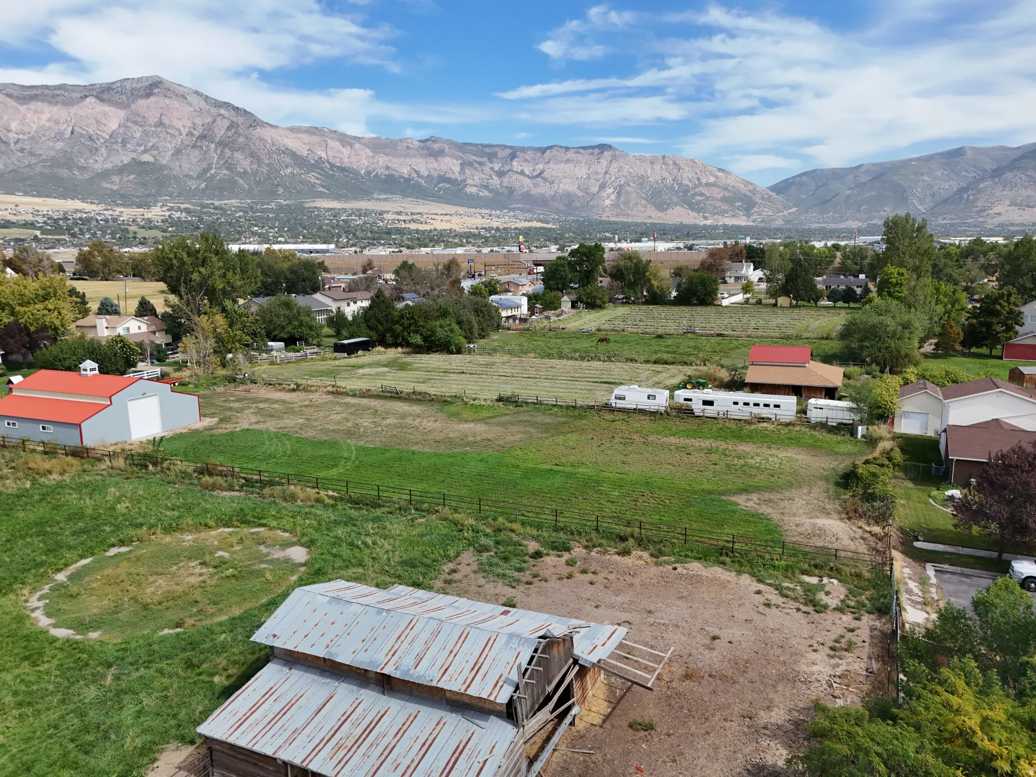 Expansive property featuring a large field, an older barn structure, mountain views, and back entrance.