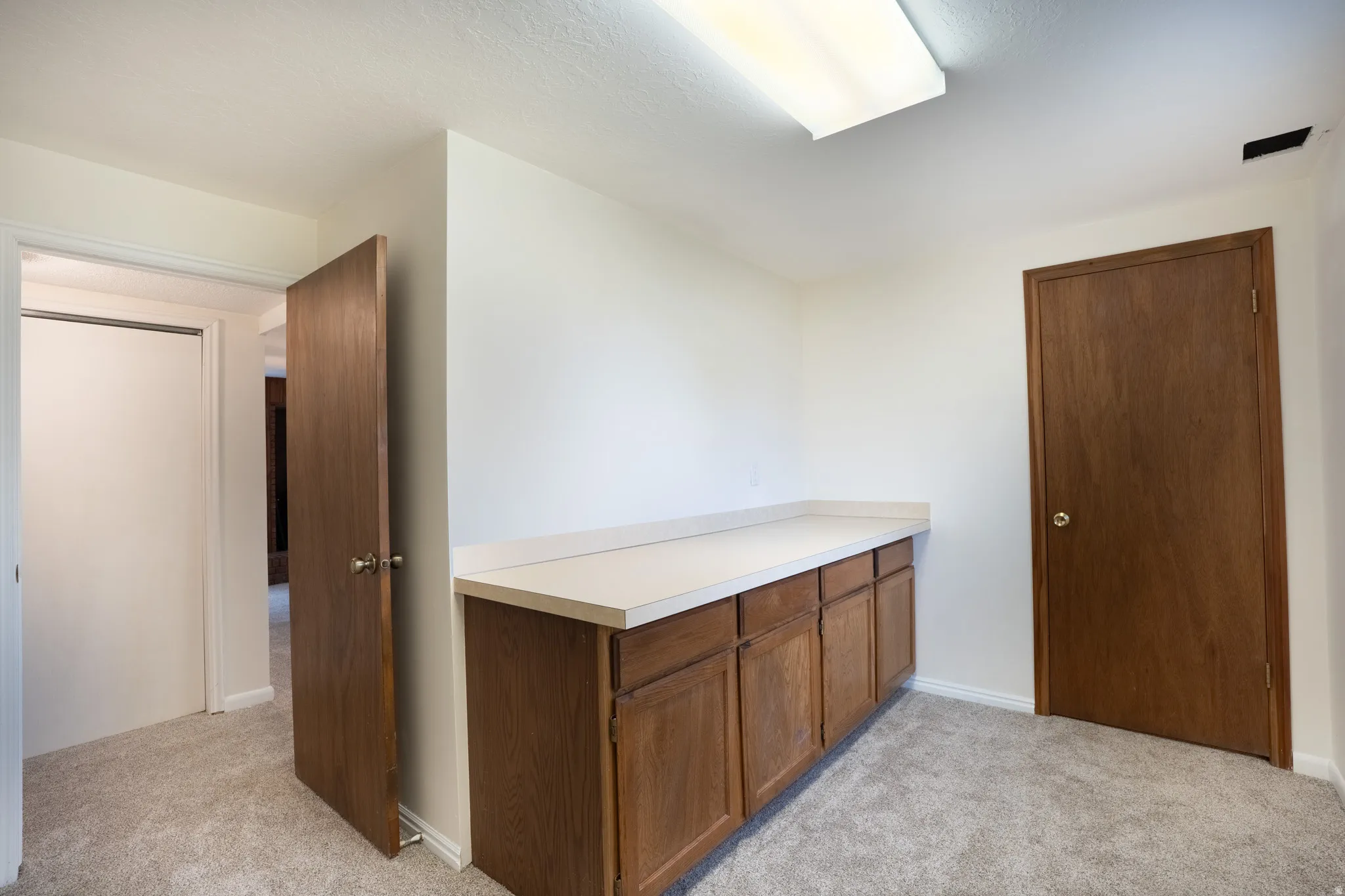 Bedroom 6 but serves as den or craft room. Built-in cabinetry with a light-toned countertop