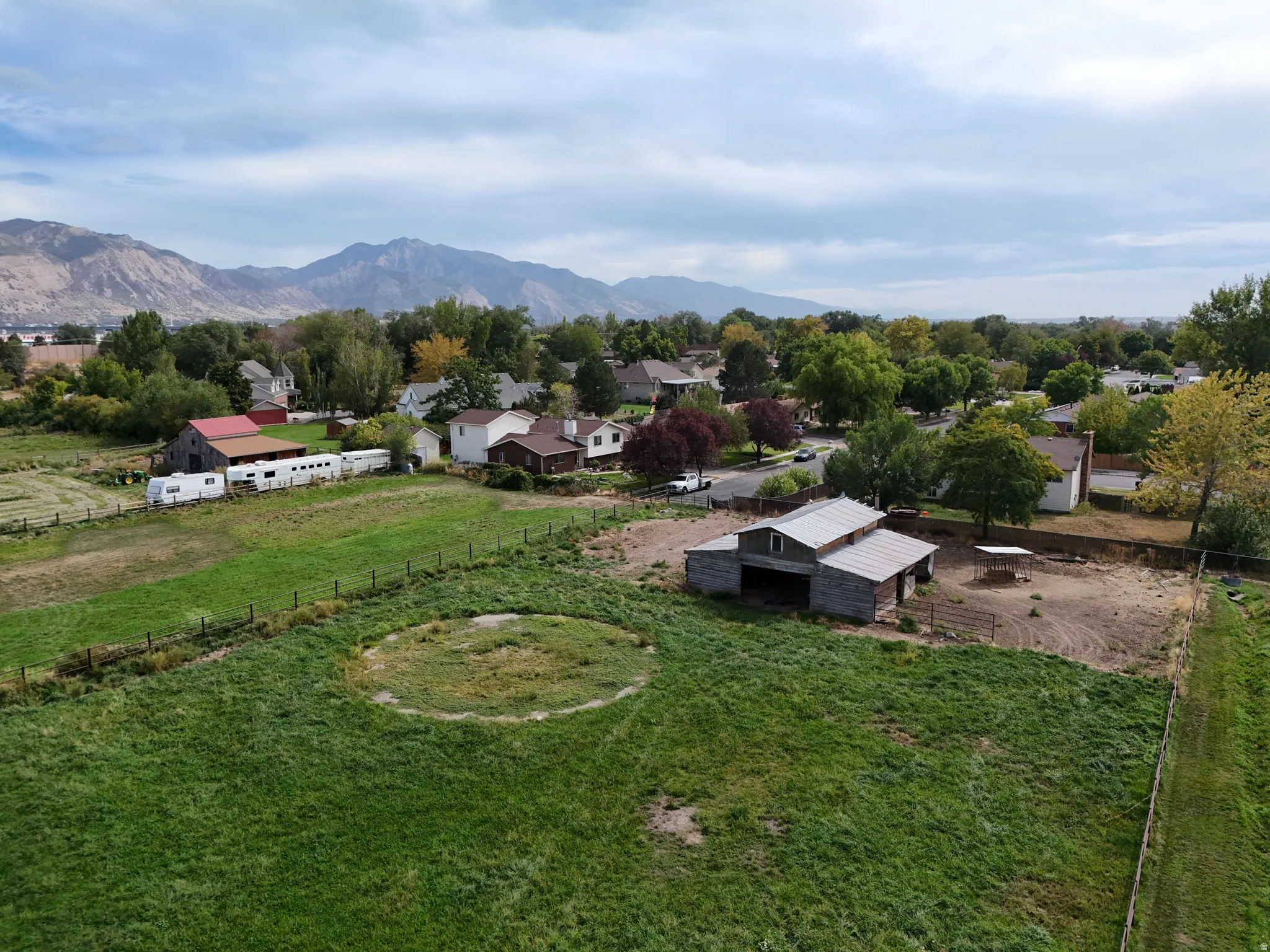 Expansive grounds featuring a large grassy area, a barn structure with a metal roof, and distant mountain scenery with back entrance from neighborhood
