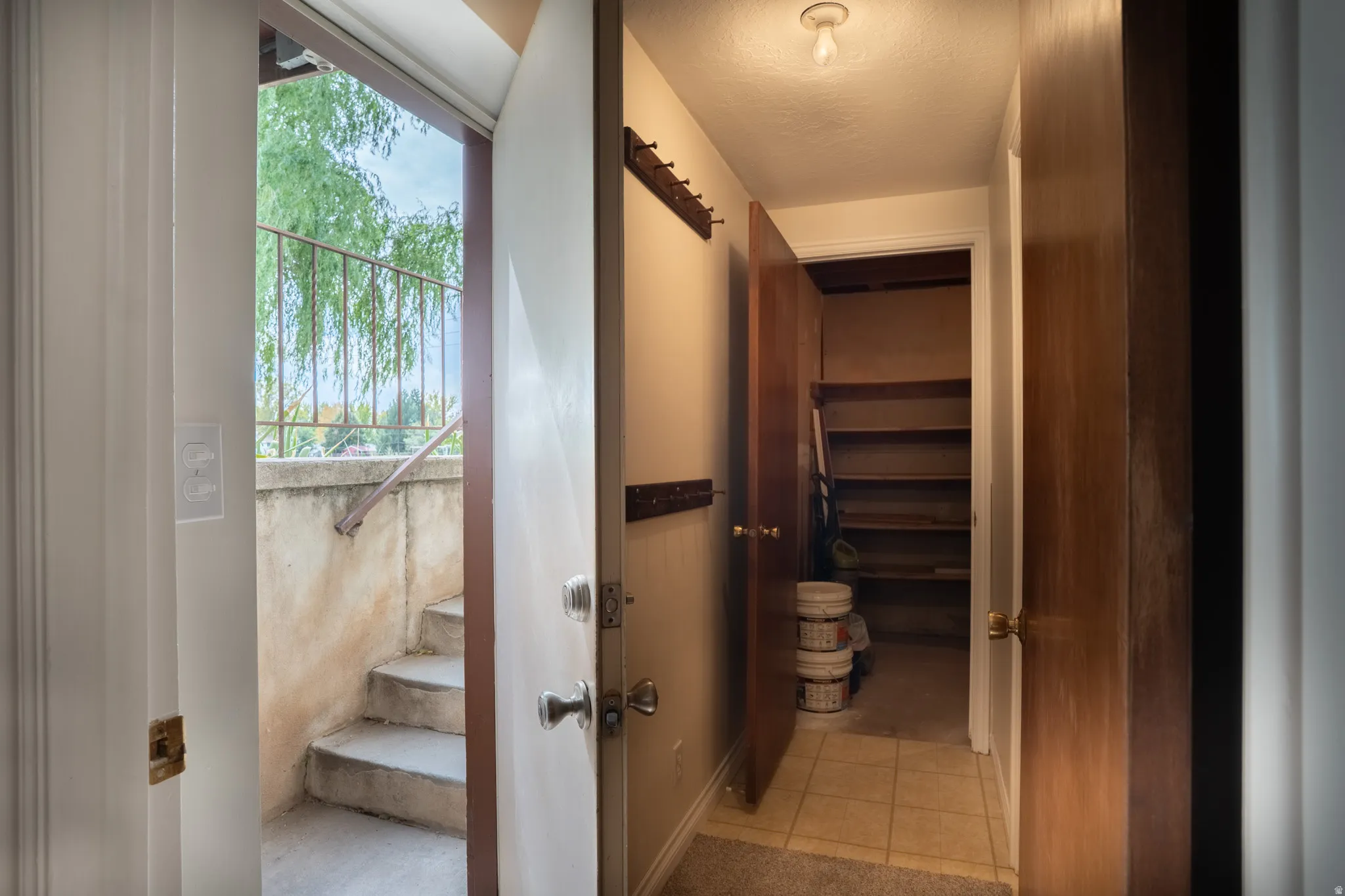 Entryway featuring a built-in coat rack, hall to the laundry and storage room, and walkout basement.