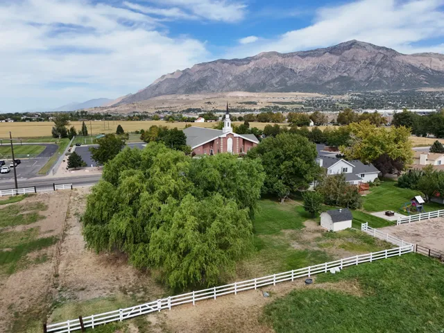 Expansive rural setting with mountain backdrop, residential structures, and natural landscaping