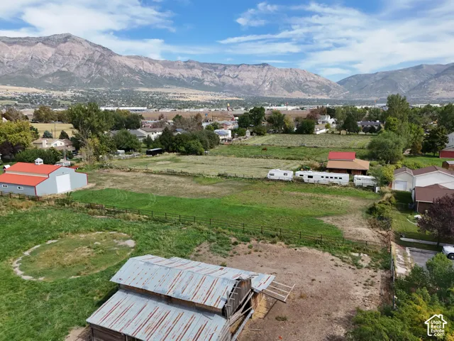 Expansive property featuring a large field, an older barn structure, mountain views, and back entrance.