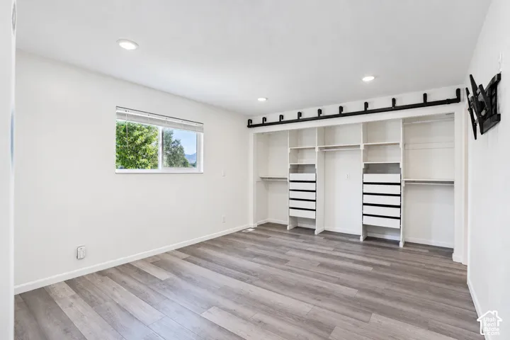 Wood-finish flooring, recessed lighting, and a white window frame