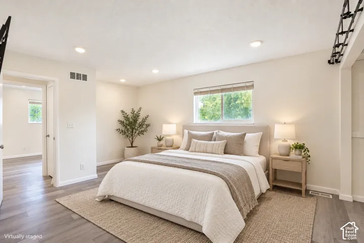 Recessed ceiling lighting, wood-finish flooring, and a large window