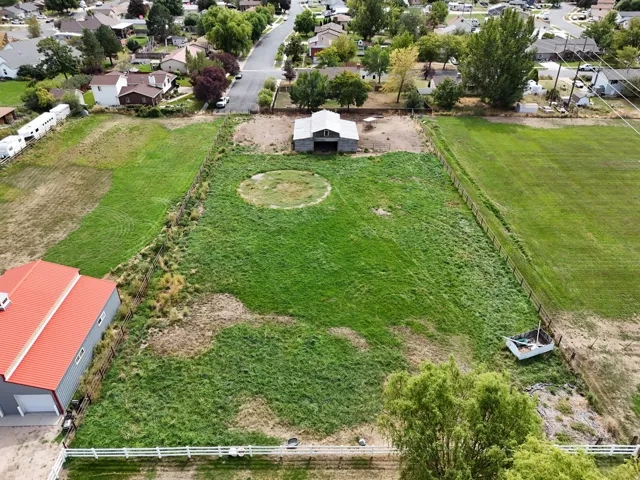 Expansive green lot featuring a rustic barn structure and former horse pasture.