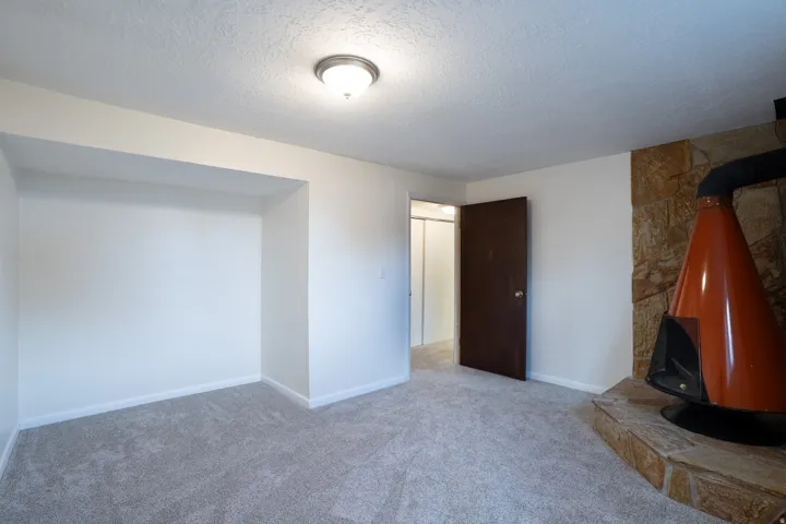 Bedroom 5 with wood burning stove, new carpet, paint, door, and baseboards