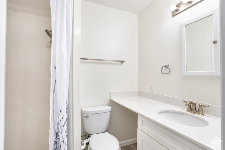 White vanity with integrated sink, brushed nickel faucet, large countertop space, and coordinating mirror
