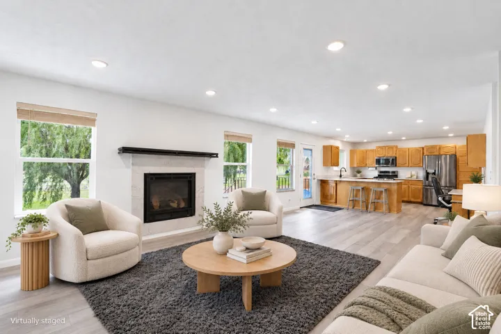 Open-concept living area featuring wood-finish flooring and recessed lighting