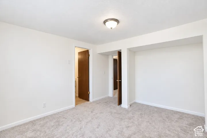 Bedroom 4 Neutral-toned wall-to-wall carpeting, white painted walls, and a recessed ceiling section