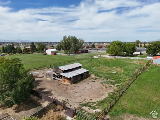 Expansive acreage featuring a rustic barn structure, split-rail fencing, and mature trees
