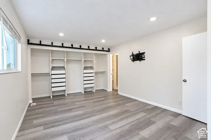 Wood-finish flooring, recessed lighting, and a window with blinds