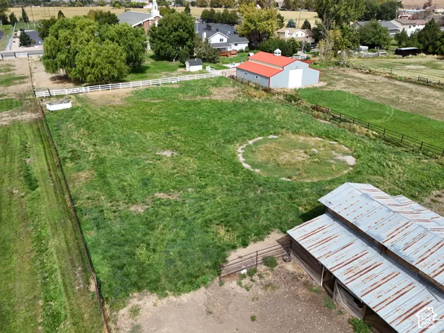 Expansive grassy lot featuring two outbuildings and perimeter fencing