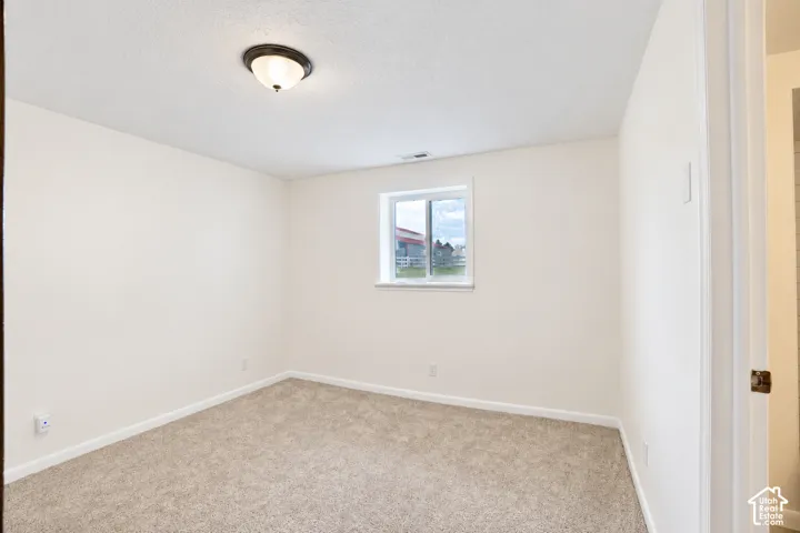 Neutral wall finishes, recessed window, and light-toned carpet