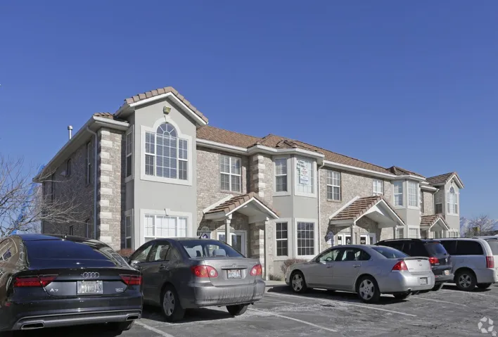 Brick and stucco facade with pitched tile roofing and decorative window arches