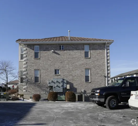 Brick exterior with decorative stone quoining, tiled roof, and multiple windows