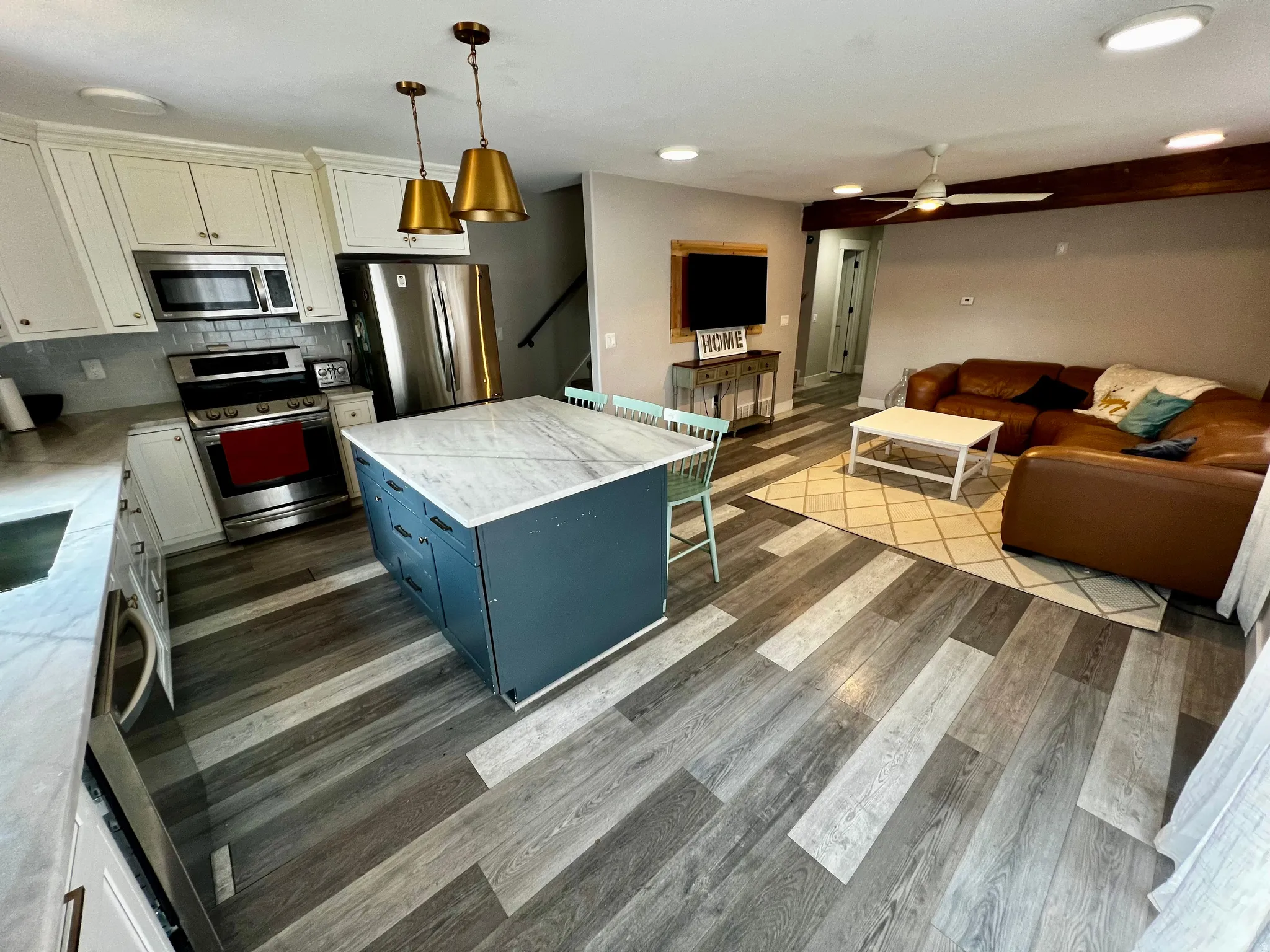 Kitchen featuring a central island with a stone countertop, white cabinetry, and stainless steel appliances