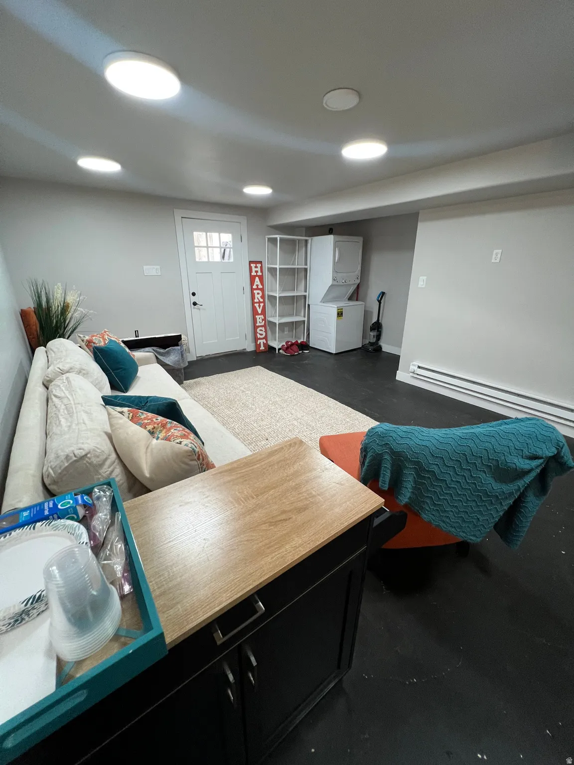 Recessed lighting, light gray wall paint, white trim, dark flooring, and a white door with a window