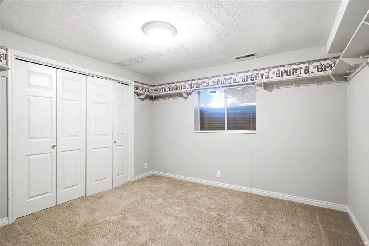Wall-to-wall carpeting, bi-fold closet doors, and recessed window