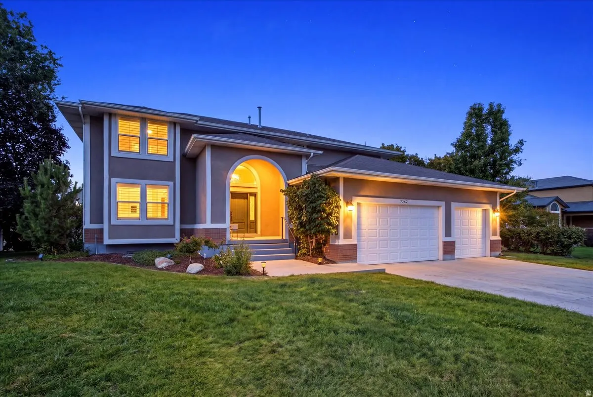 Stucco exterior with an arched entryway, two-car garage, and a concrete driveway