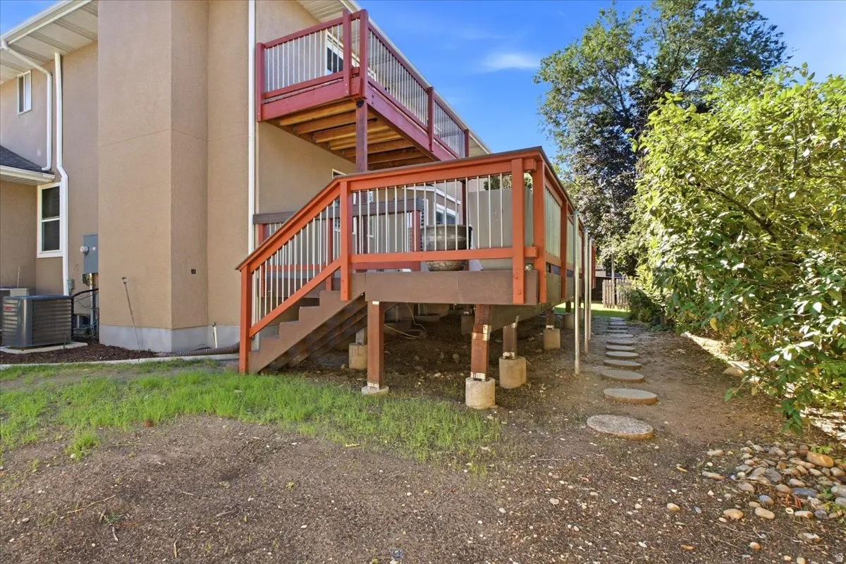 Multi-level decking with red-stained railings and glass panel accents