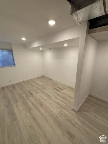Recessed lighting throughout, wood-finish flooring, and white walls