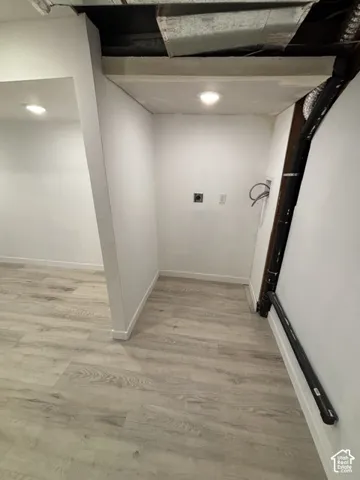 Wood-finish flooring with white walls and recessed ceiling lighting
