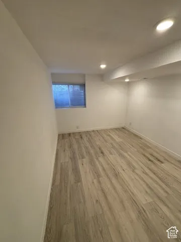 Recessed lighting, wood-finish flooring, and white painted walls