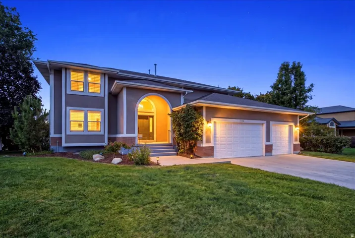 Stucco exterior with an arched entryway, two-car garage, and a concrete driveway