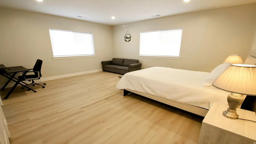 Recessed lighting, light-toned walls, wood-finish flooring, and multiple windows