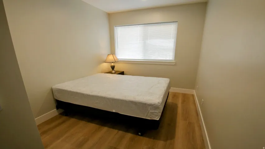 Wood-finish flooring, neutral wall tones, and a window with blinds
