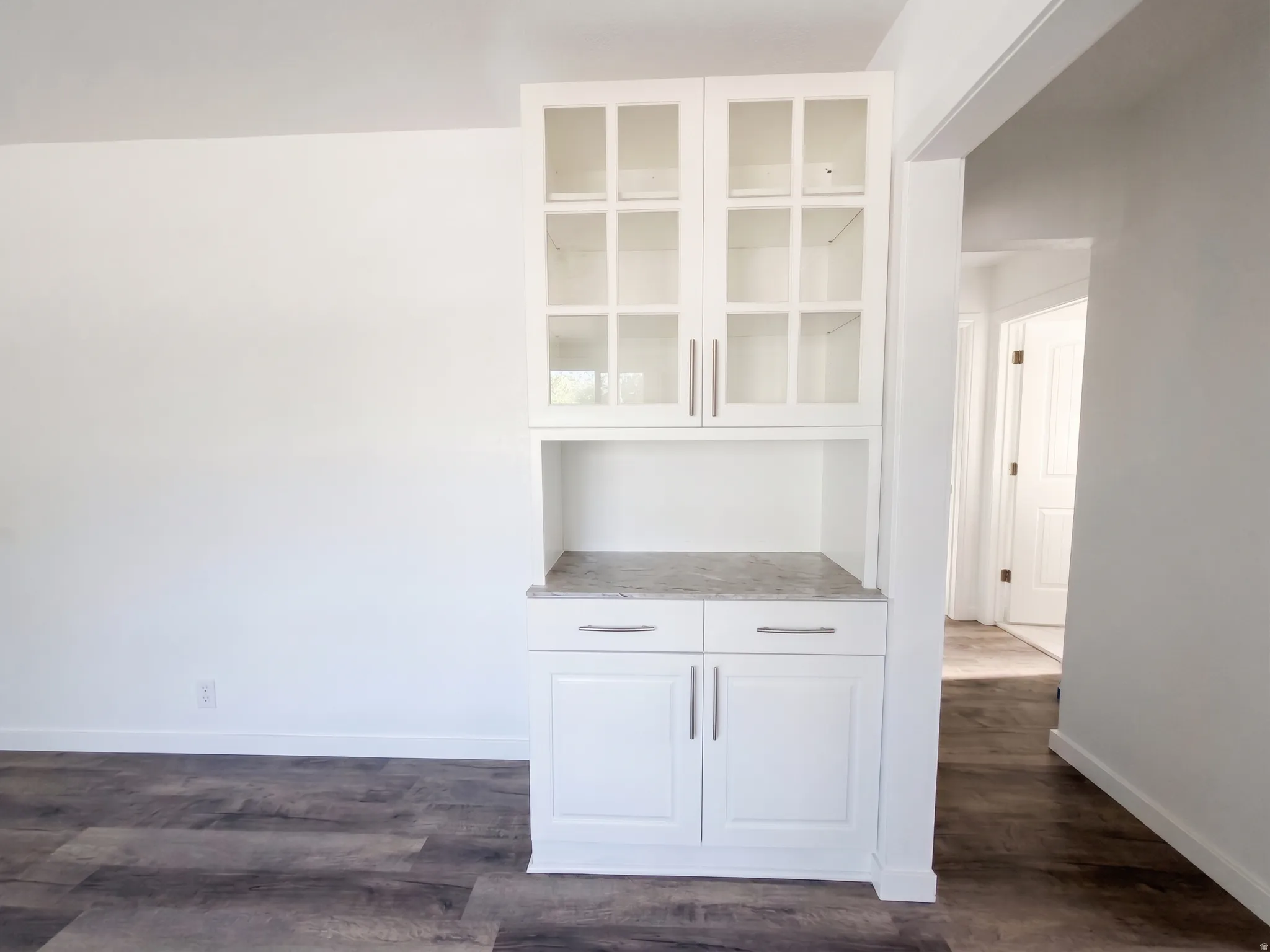 Built-in cabinetry with glass-paneled upper doors, lower storage, and a light-toned countertop