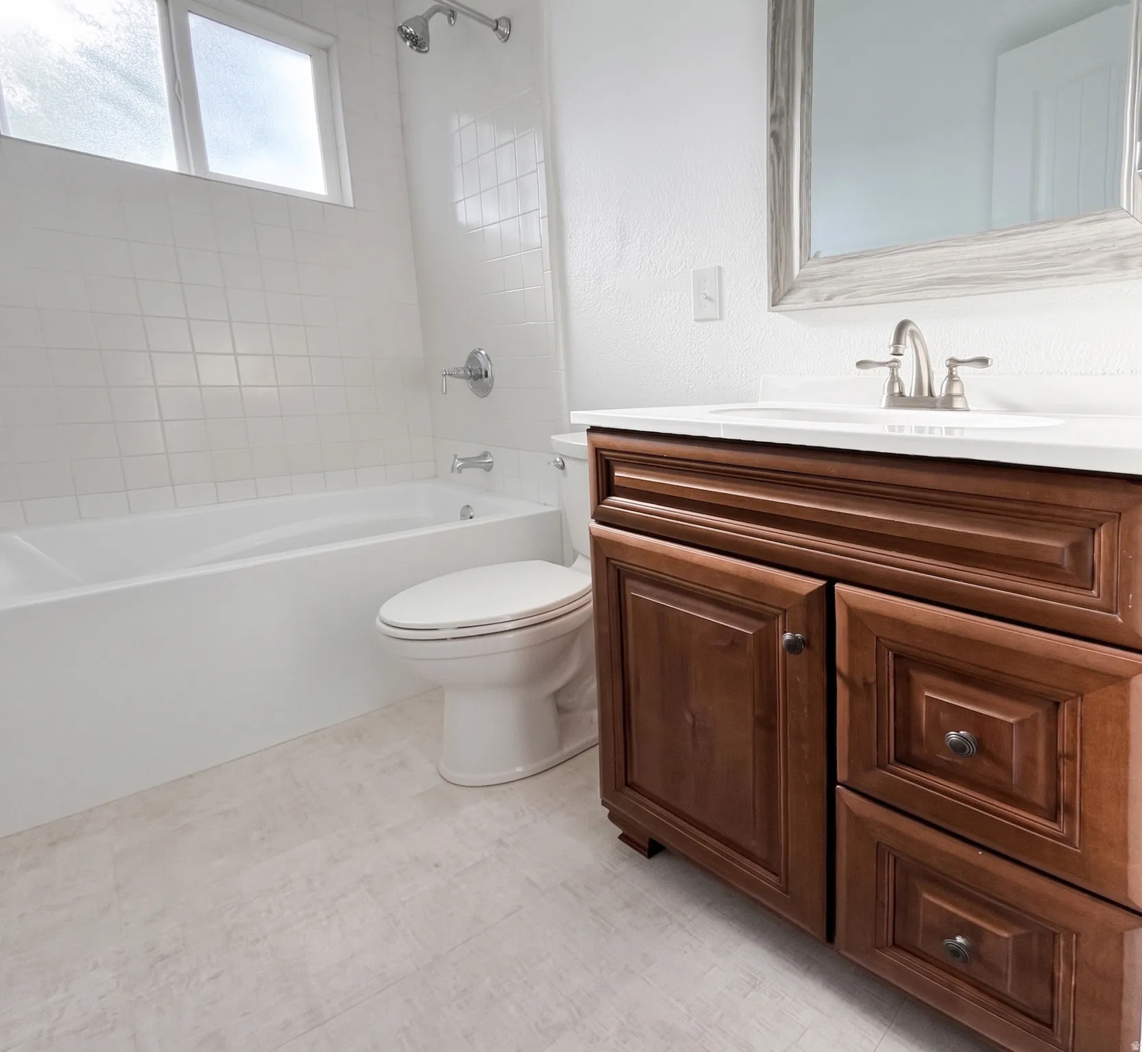 White tile shower surround with chrome fixtures, built-in bathtub, and a window for natural light