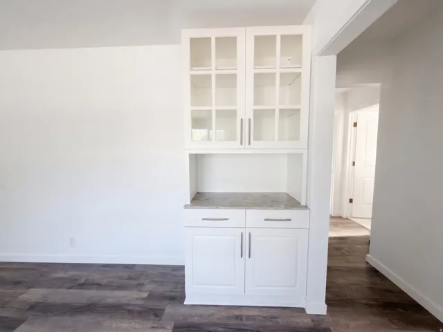 Built-in cabinetry with glass-paneled upper doors, lower storage, and a light-toned countertop