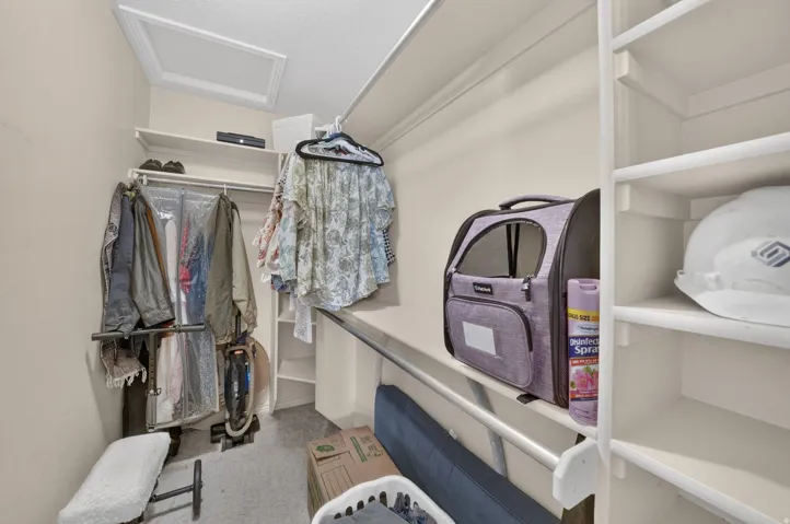 Built-in shelving, multiple clothing rods, and an overhead access panel
