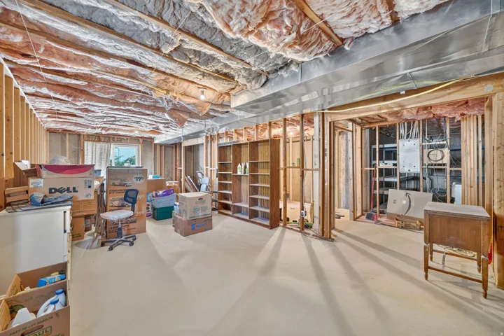 Unfinished interior space featuring exposed wood framing, ceiling insulation, and a single window
