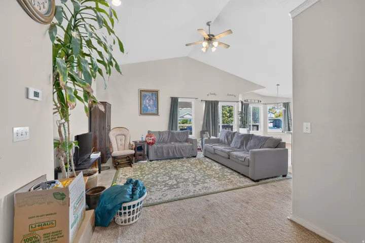 Vaulted ceiling with an integrated ceiling fan, recessed lighting, and large windows offering exterior views