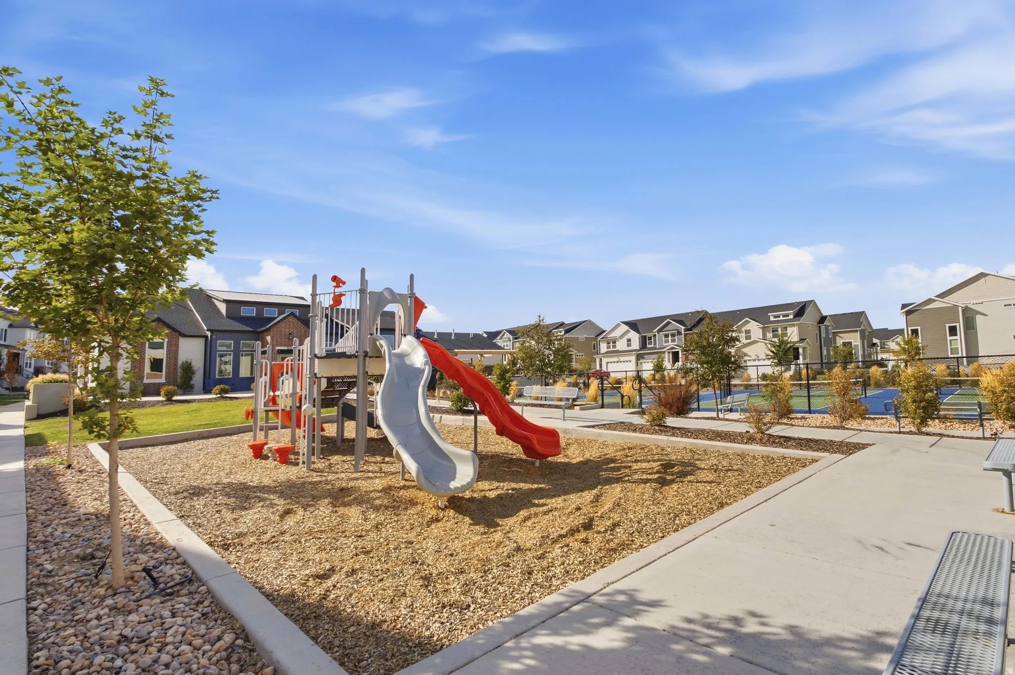 Community playground with wood chip surfacing, slides, and climbing features