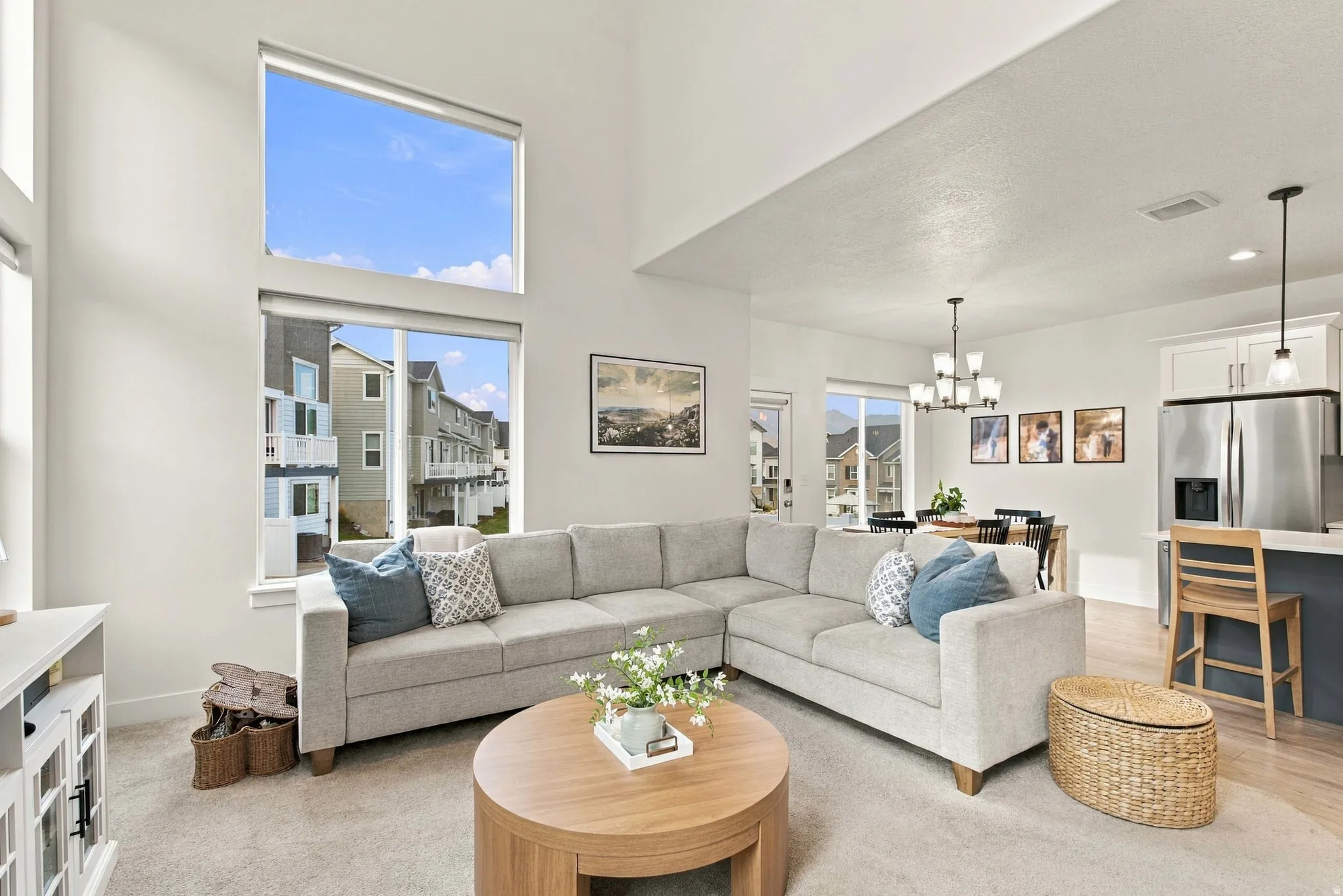 Vaulted ceiling, prominent upper windows, recessed lighting, chandelier, and wood-finish flooring