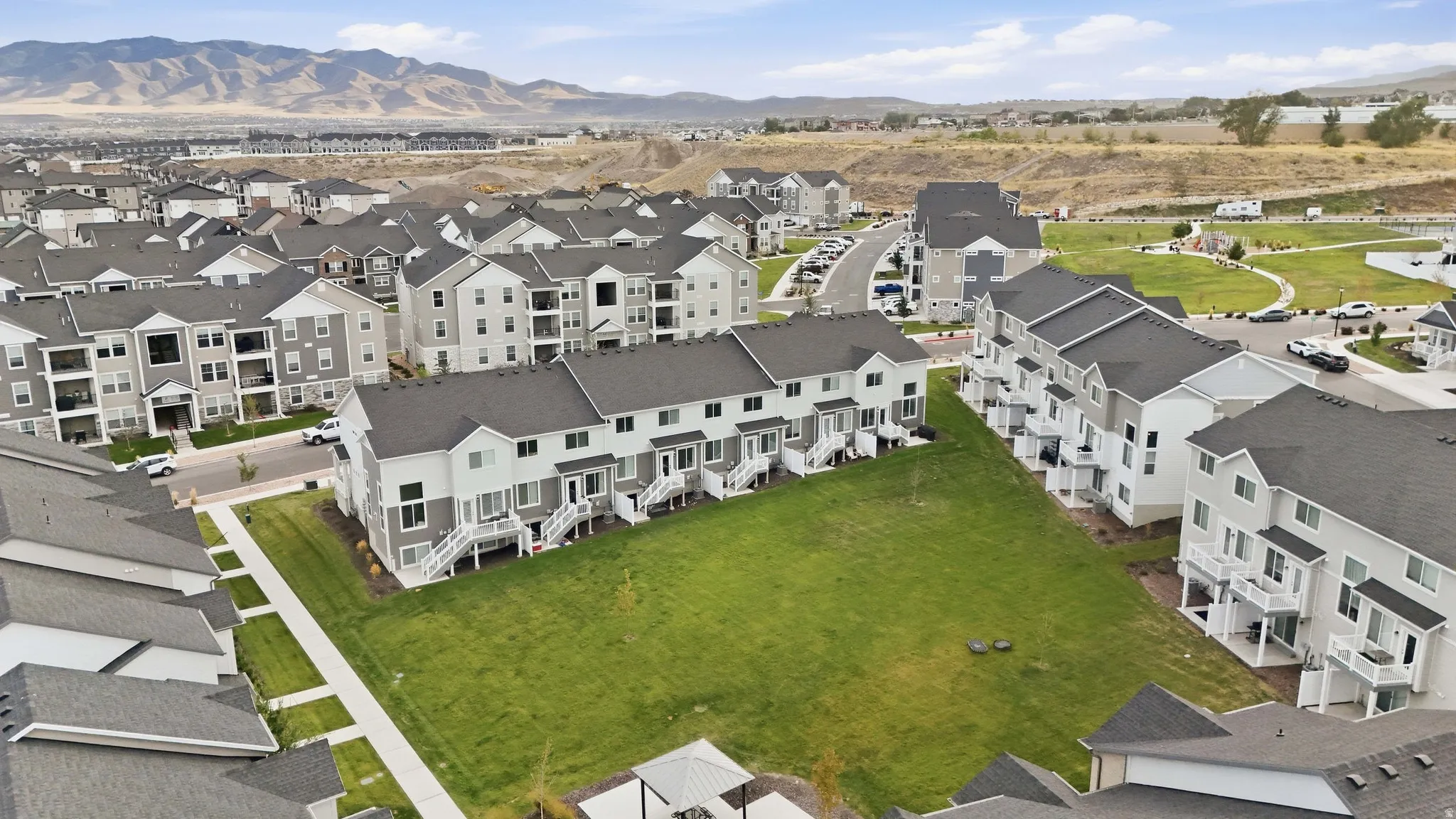 Townhome community with extensive green spaces, private balconies, and mountain backdrop