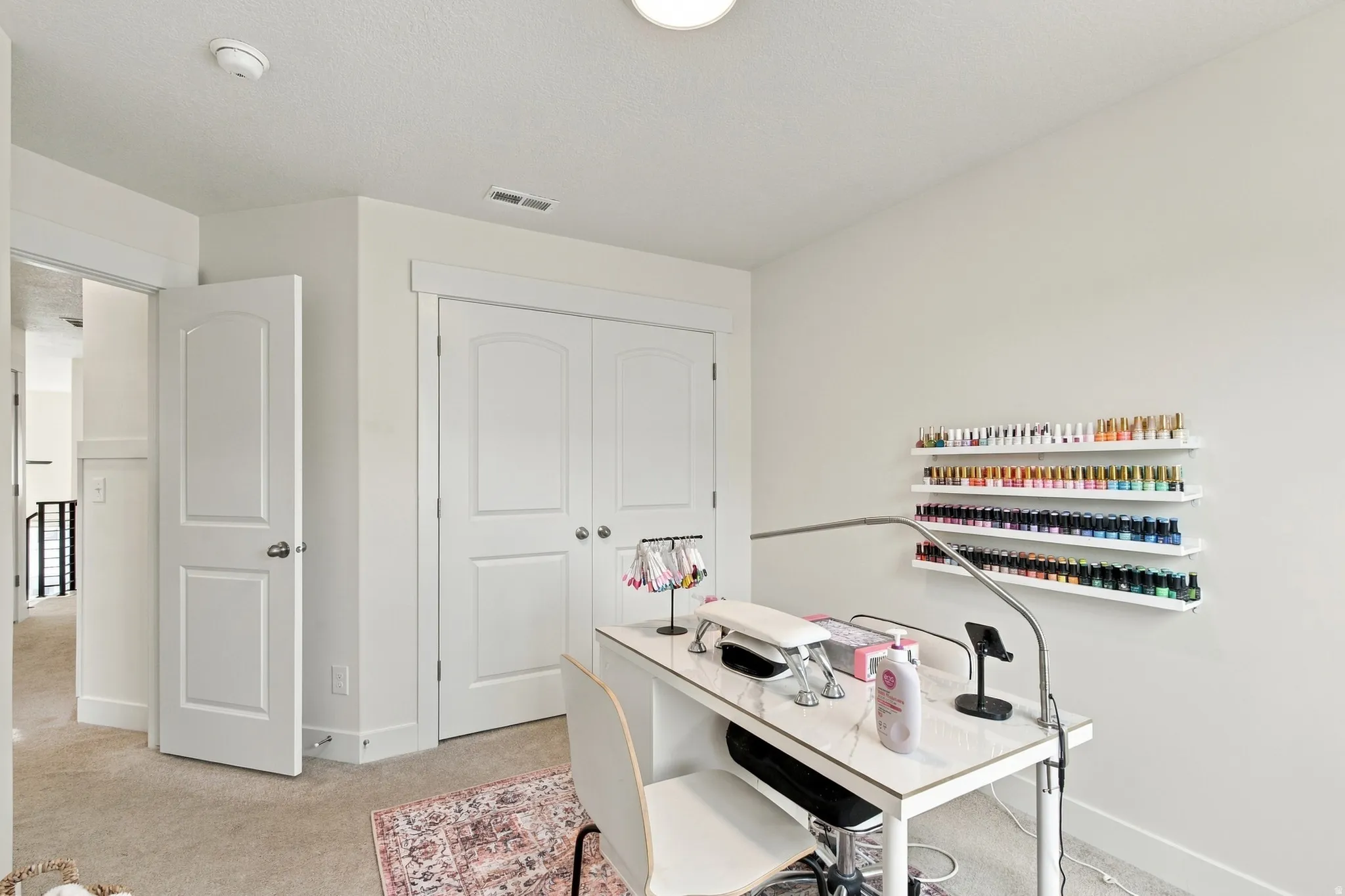 Carpeted flooring, white interior doors, and a double-door closet