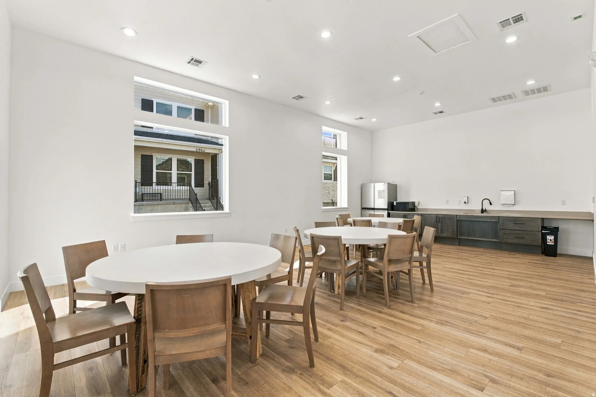 Spacious common area featuring wood-finish flooring, recessed lighting, and large windows