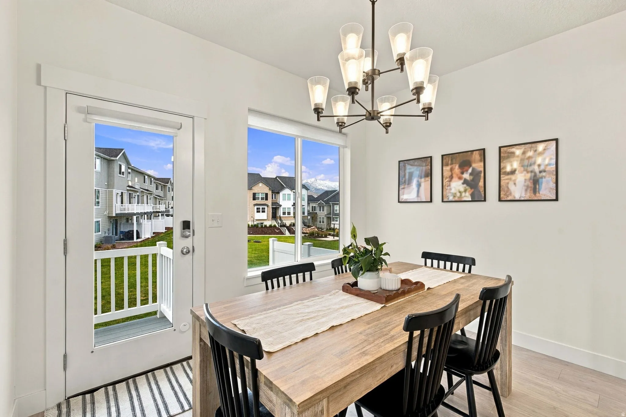 Dining area featuring a contemporary chandelier, wood-finish flooring, and white walls