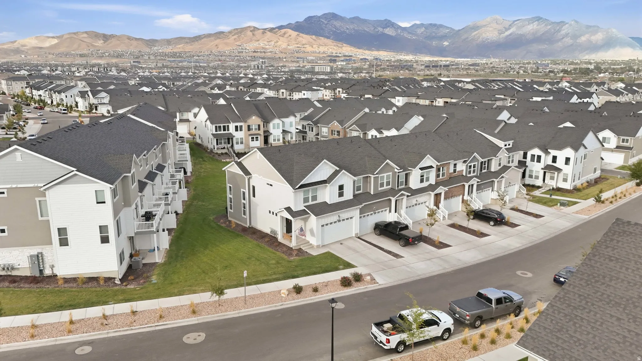 Mountain backdrop framing a residential community with contemporary townhomes and detached residences